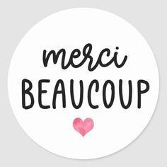 a round sticker with the words merci beaucoup written in black ink