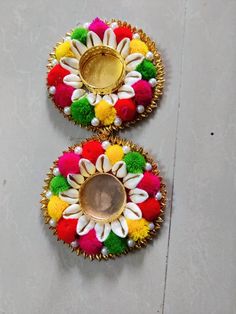 two colorfully decorated dishes sitting on top of a white floor