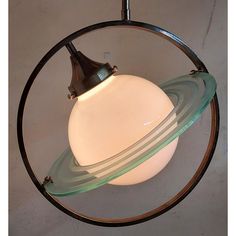 a light hanging from the ceiling in a circular fixture with an object on it's side