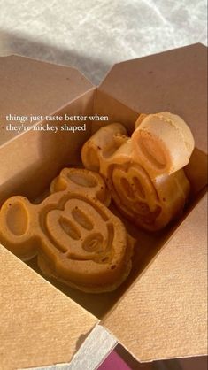 an open box with some cookies in it and a quote on the inside that says, things just taste better when they're mickey shaped