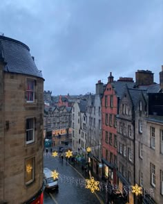 a city street filled with lots of traffic and christmas lights on the side of buildings