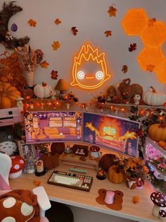 a desk topped with lots of computer screens and pumpkins on top of the desk