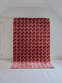 a red blanket sitting on top of a white floor next to a closet and door