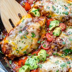 a skillet with chicken, tomatoes and avocado on it is ready to be eaten