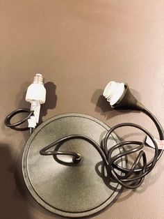 two different types of electrical cords and plugs on top of a round table with a brown surface