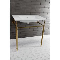 a white sink sitting on top of a metal stand in front of a brick wall