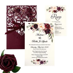 the wedding card is decorated with red flowers and burgundy paper, along with a rose