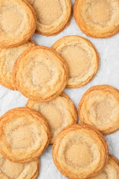 a pile of sugar cookies sitting on top of a white paper covered in powdered sugar