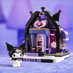 a small doll house with a black and white cat figurine next to it