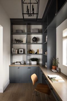 an office with gray cabinets and wooden flooring is pictured in this image, there are two chairs at the desk