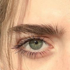 a woman's green eye with long lashes