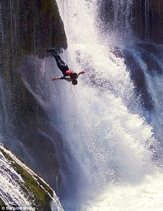 a man falling off the side of a waterfall