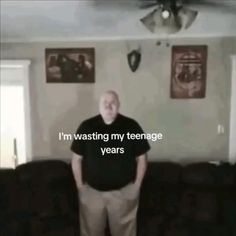 a man standing in front of a couch with the words i'm wasted my teenage years on it