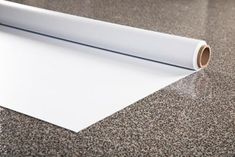 a roll of white paper sitting on top of a countertop next to a wall