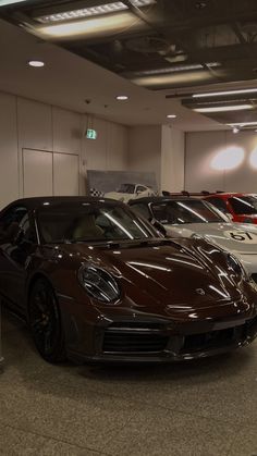 there are many cars parked in the garage together, and one is brown with black accents