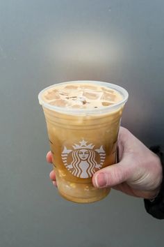 a person holding up a starbucks drink in their hand