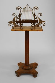 an ornate wooden stand with a birdcage on it's top and bottom