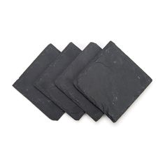 four pieces of slate sitting on top of each other in front of a white background