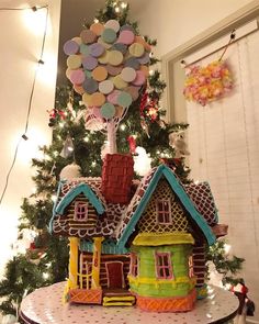 a christmas tree with a house and balloons on top