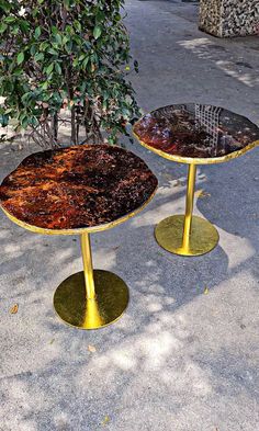 two tables sitting on top of each other near a tree