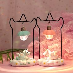 three little lights that are on top of a pink cake with flowers in the background