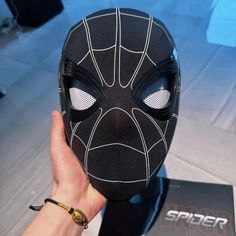 a person holding up a black mask with white lines on it