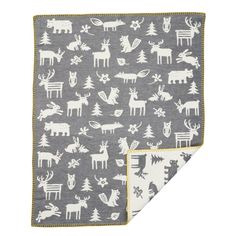 a gray and white blanket with deers, trees, and snowflakes on it