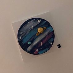 a clock that is on the side of a wall with stars and planets painted on it