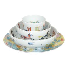 three bowls and two plates with cartoon designs on them, all stacked up in the same row