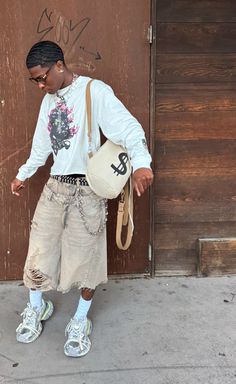 a young man is standing in front of a door with his handbag on his hip