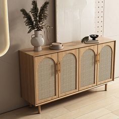 a sideboard with two vases and a plant on it next to a wall