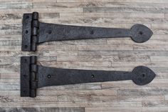 two black iron door handles on a wooden floor