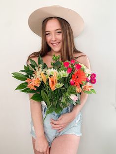 a young woman is holding a bouquet of flowers