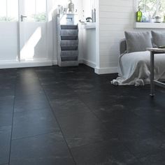 a living room with black tile floors and white walls