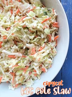 a bowl filled with coleslaw and carrots on top of a blue table