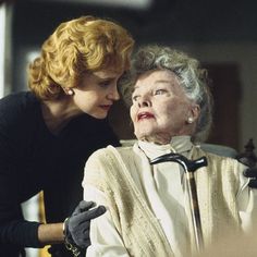 an older woman sitting in a chair next to another woman