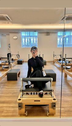 a man sitting on top of a machine in a gym