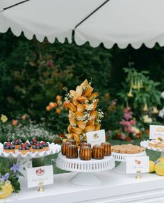 an assortment of pastries and desserts on a table in front of a tent