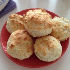 some biscuits on a red plate next to a bottle of milk