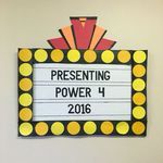 a sign that says presenting power 4 in front of a white wall with yellow dots