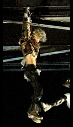 lady dancing on stage with her reflection in the wet floor and lights reflecting off to the side