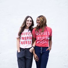 two women standing next to each other in front of a white wall wearing nurses t - shirts