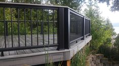 a wooden deck with metal railing overlooking the water