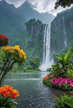 the waterfall is surrounded by colorful flowers and greenery