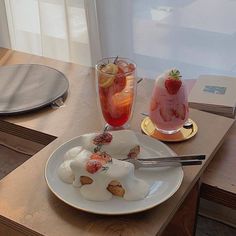 a table topped with two plates filled with desserts next to a glass of wine