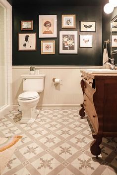 the bathroom is decorated in black and white with pictures on the wall above the toilet