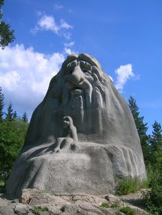 a sand sculpture of a man and woman with trees in the background