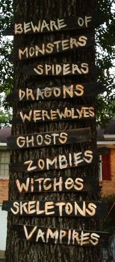 a sign on a tree that says beware of monsters, spiders, werewolvess, ghostes, witches, skeletons, skeletons, skeleons, and vampires