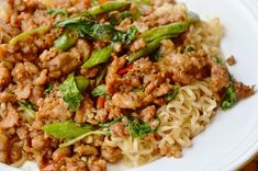 a white plate topped with noodles and meat