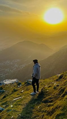 a man standing on top of a lush green hillside